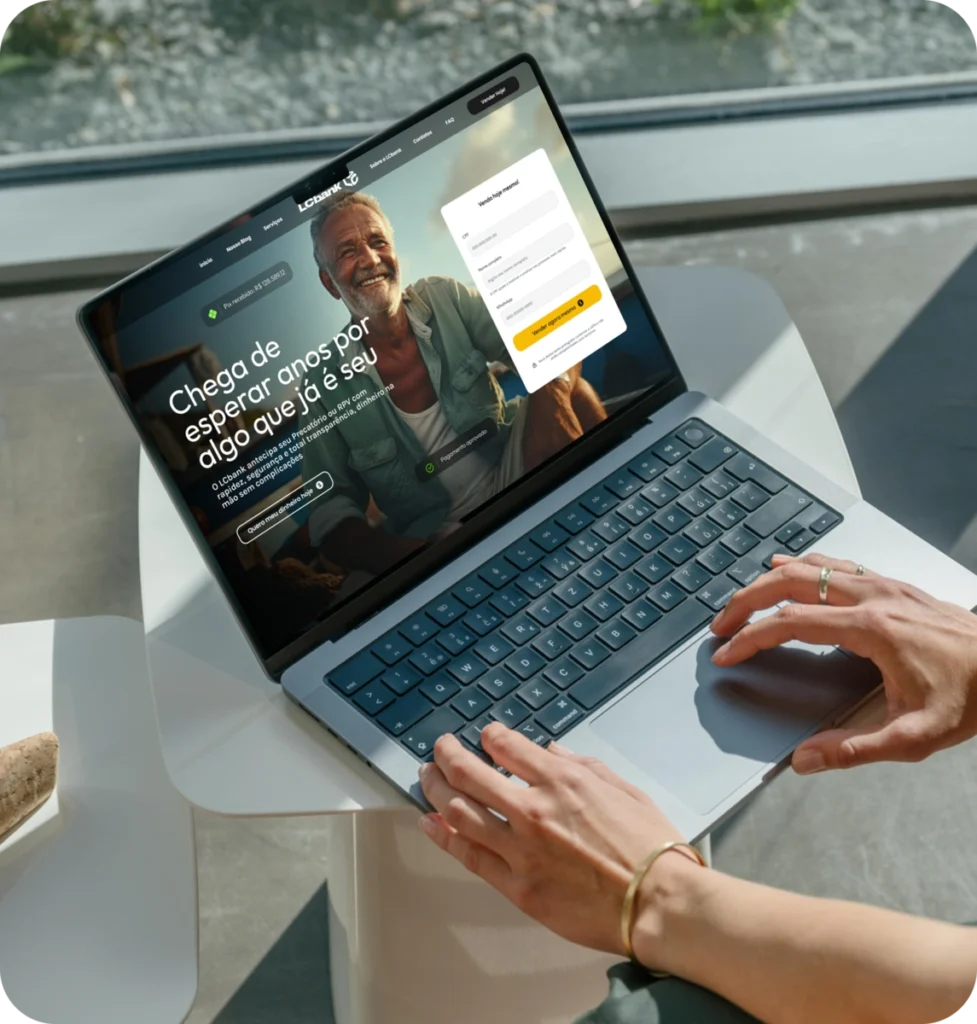 Laptop aberto com tela exibindo site do LCbank e formulário de login